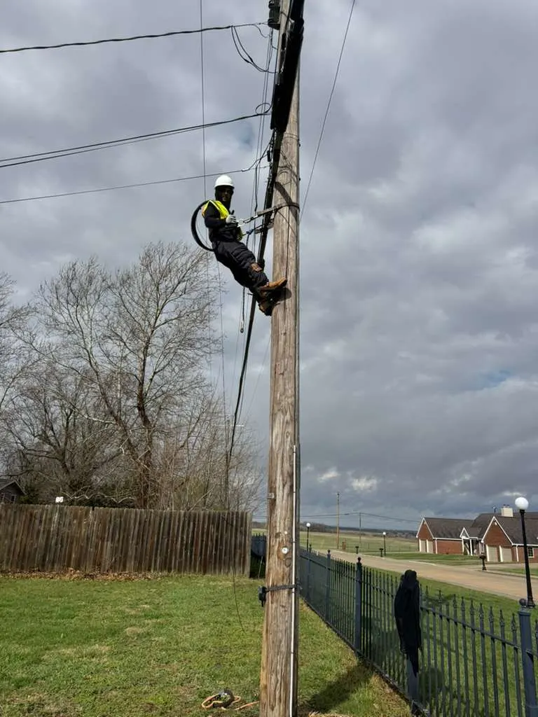 Technician working on aerial fiber infrastructure on a utility pole